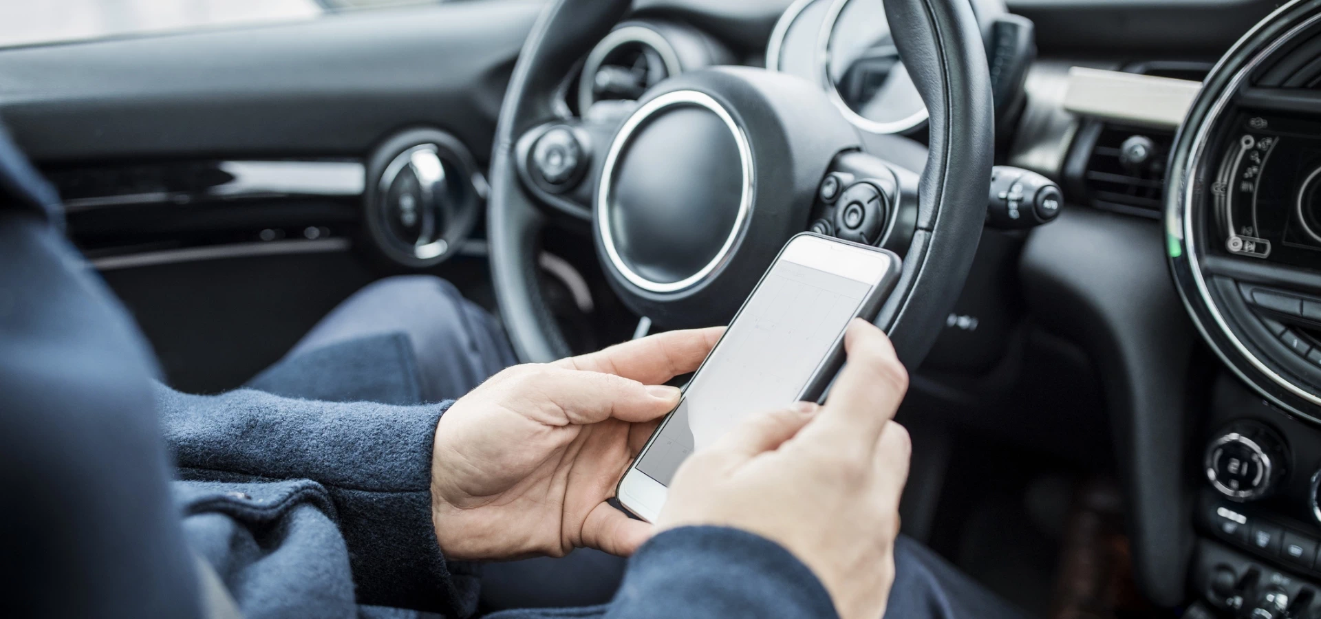 telefon komórkowy w dłoniach u kierowcy samochodu
